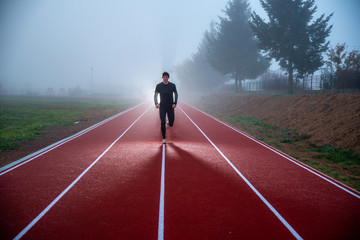 Running concept photo. Athlete silhouette, active man run and jump in morning over misty blue sky. Sport photo, edit space