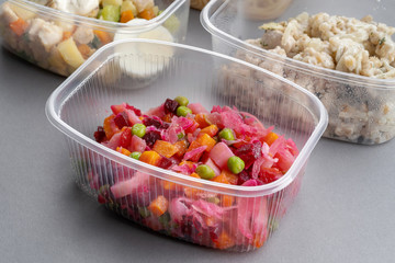 Jar with Venegret in the foreground. Pasta with minced meat and onion in navy-style and a jar of vinaigrette on a gray background.