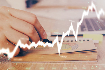 Multi exposure closeup hands with stock market forex graph.
