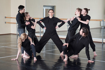 Woman with outstretched legs and group of young people exercising together