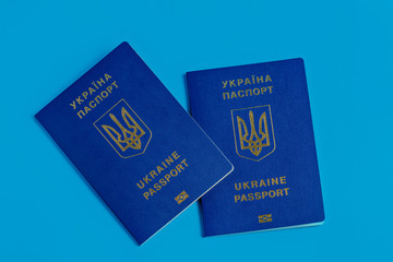 Two Ukrainian passports with a golden trident symbol on a blue blue background. Biomedical Ukraine passport id