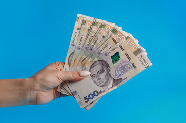 500 hryvnia in the hand of a girl advertising the hand of a girl with money on a blue background bill 500 hryvnia