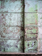 Old concrete wall with worn out green painting