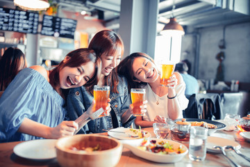 happy young woman sitting in  restaurant and enjoy dinner and beer