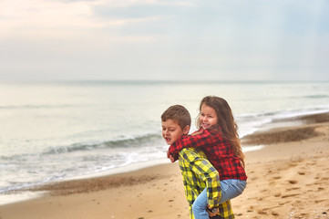 Brother and sister on a walk along the sea on a spring day