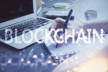 Cryptocurrency hologram over hands taking notes background. Concept of blockchain. Multi exposure