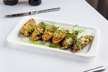 Appetizing mussels with filling, side view, white plate