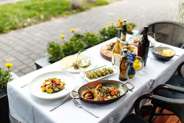 White table served with delicious italian food, horizontal, side view, vegetables, chicken, grill, seafood