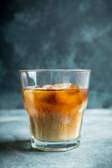 White russian cocktail with ice and cream liquor. Selective focus. Shallow depth of field.