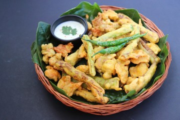 Mixed veg pakode or bhajiya, Pakodi, Bhaji is crisp fried spicy snack made using vegetables like chili, onion, potatoes, raw jack fruit, chickpea flour and spices. It is a popular street food in India