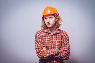 Handsome young man with protective helmet on his head and arms crossed