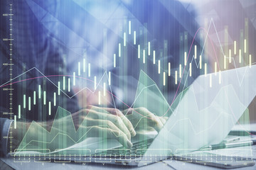 Double exposure of market chart with man working on computer on background. Concept of financial analysis.