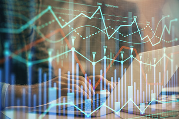 Double exposure of market chart with man working on computer on background. Concept of financial analysis.