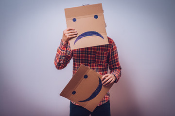 man  holding a picture with a unhappy smiley