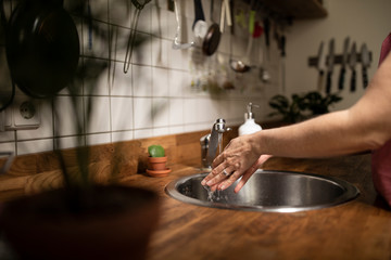 Woman washes her hands with soap.