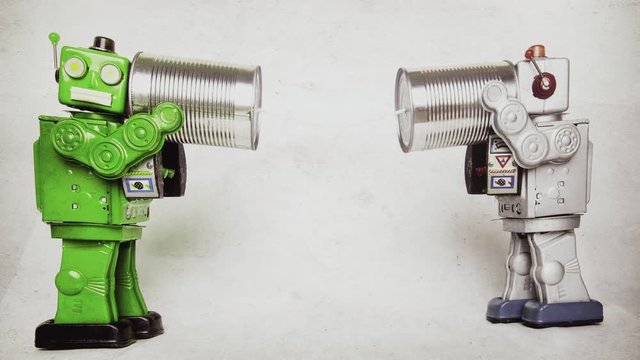 two retro robots on tin can phones