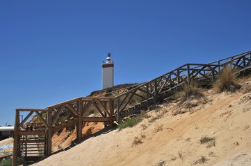 Fototapeta na wymiar Lighthouse on the Atlantic Ocean in Matalascanas