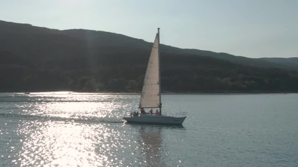 Circling drone shot around men on a sailboat on bachelor party
