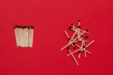 Used and unused matches on red background. Order and chaos, dead or  alive, healthy and sick, fresh and rotten, good and bad, free and captive, self-isolation, quarantine concept.