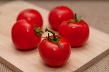 Fresh, ripe tomatoes on wooden background, close-up shot
