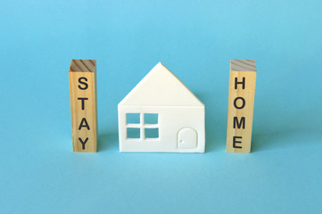 Stay home, stay safe photo with a house on a blue background.