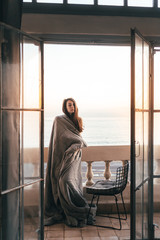 Girl at dawn in the sun sits on the balcony of an old colonial house on the Caribbean