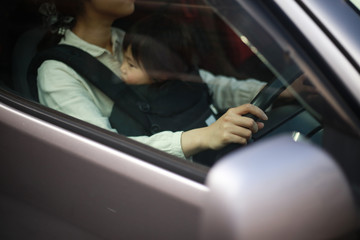 子供を抱っこしたまま運転する女性