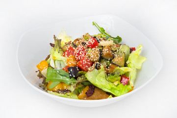 Salad of fried pepper, eggplant, and tomato in a hot vegetable oil with fresh cabbage, greens, including sorrel, poured on top with vegetable oil with lemon juice and sprinkled with sesame seeds