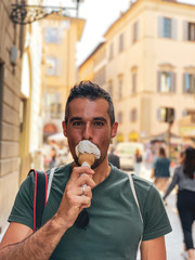Tourist isst ein Eis in belebter italienischer Stadt vor der Corona Pandemie