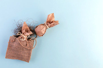 Easter flat layout of burlap, eggs in craft paper on a blue background. The concept of eco-friendly minimalistic consumption of gifts. Copy space