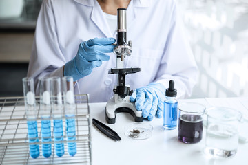 Fototapeta premium Biochemistry laboratory research, Chemist is analyzing sample in laboratory with Microscope equipment and science experiments glassware containing chemical liquid