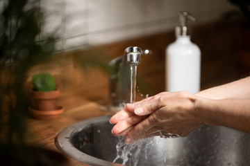Woman washing her hands with soap