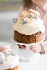 A happy little girl looking at an eastern cake. Easter concept. Traditional homemade easter and girl. Easter holidays breakfast concept. Traditional home decorated cake. Happy easter.