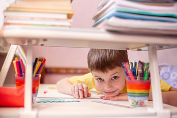 Child doing homework with books and textbooks at home. Learning at home, self quarantine concept. Family at home. Epidemic of coronavirus. Self-isolation, home quarantine. Distance learning at home.