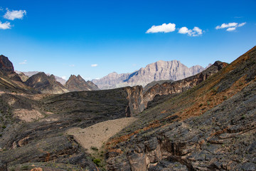 Fototapeta na wymiar Mountain and valley view along Wadi Sahtan road and snake canyon in Al Hajir mountains between Nizwa and Mascat in Oman