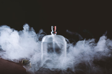 Men's perfume in smoke on a black background