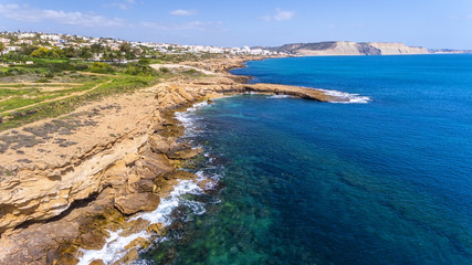 Aerial view of the stone shores of southern Portuguese beaches, crystal water, the village of Luz.