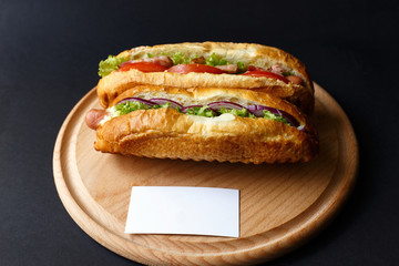 Two hot dogs lying on the wooden plate. Mock up.