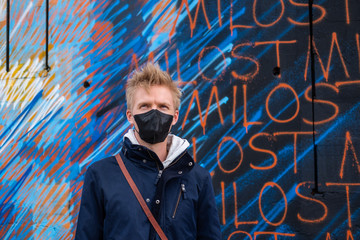 European man travel wearing black face protection agains coronavirus