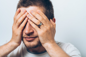 Fototapeta premium Man closes eyes with her hands