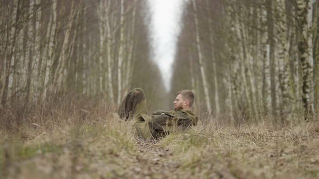 Caucasian man lies in the forest on the railway rails, autumn day