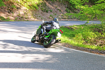 Sporty motorcyclist photographed from behind 