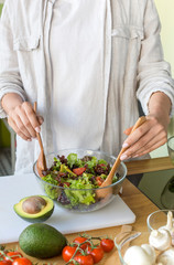 Woman preparing vitamin vegetable salad at home