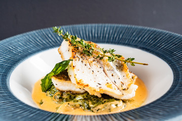 Fried fish fillet. Cod with sauce and herbs
