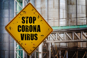 Obraz premium Stop coronavirus text on yellow grunge sign on industrial background.Covid-19 quarantine. Coronavirus infection warning sign. Stop Coronovirus design concept.