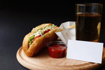 Hot Dogs with French fries and ketchup on wooden plate.