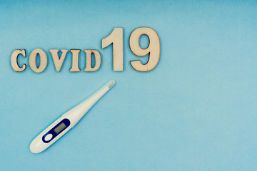 Coronavirus, Covid-19. The inscription covid-19 and an electronic thermometer on a blue background....