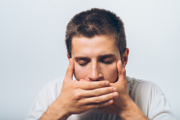 Obraz premium man closes a mouth hands
