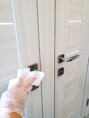 Surface of common use door handles are wiped with a disinfecting cloth to prevent the spread of the...
