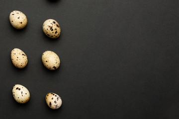 Quail eggs close-up on a black background with copyspace.Holiday easter, minimalistic black composition